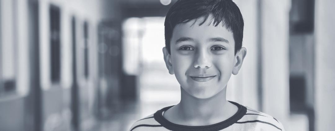 young boy standing in a school hallway