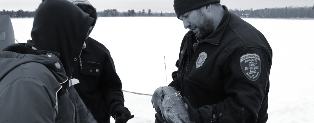 Onamia Conversation Officer Dan Starr teaches youth tips on ice fishing
