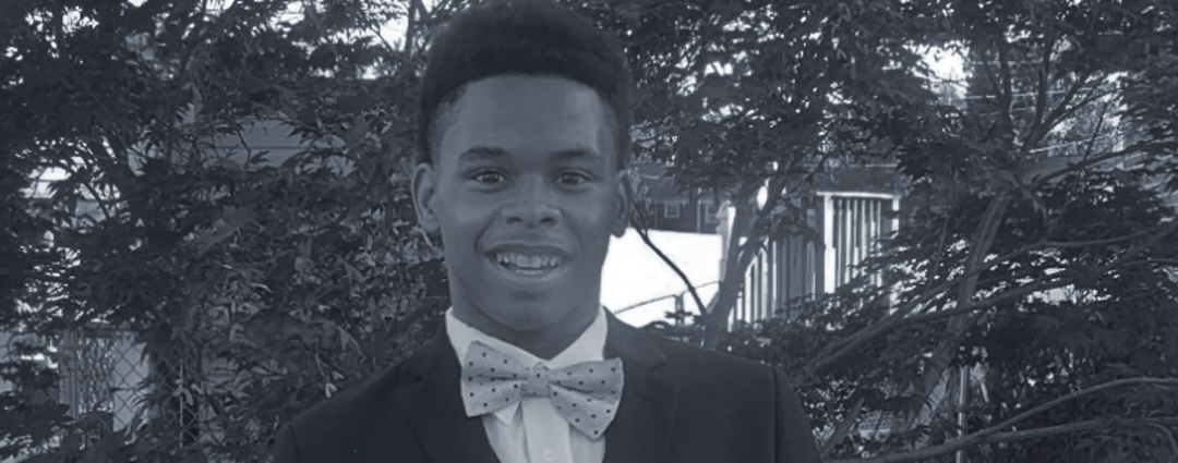 Josh, a Black teenage boy, dressed in a tuxedo for a school dance.