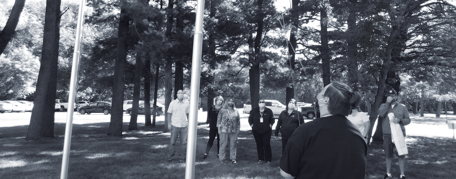 youth and staff raising LGBTQ flags