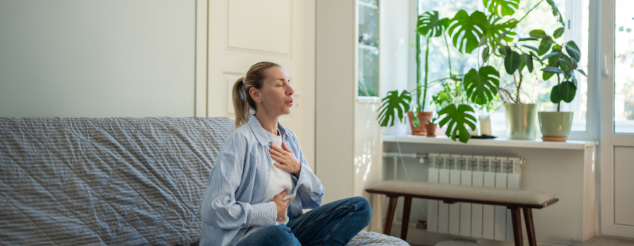 woman self-soothing with deep breaths with hand on chest