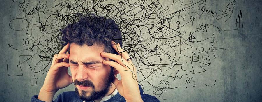 Photo of a man holding his head with illustrated squiggle lines coming from his head indicating a feeling of distraction and frustration
