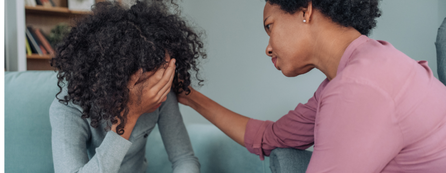 Parent or caretaker consoling a teenage girl in distress