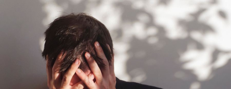A white male holding his head in his hands