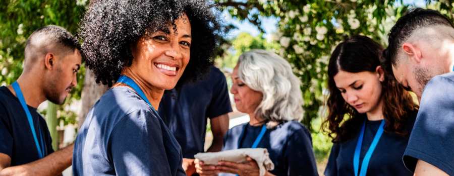group of adults working together with a multiracial female smiling at the camera