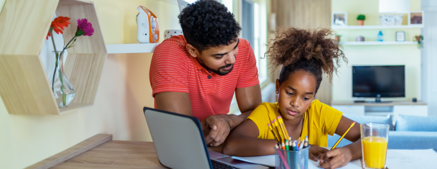 Picture of a father helping his daughter with homework.