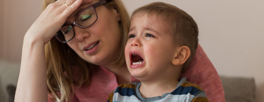 Picture of a mother frustrated as her toddler cries.