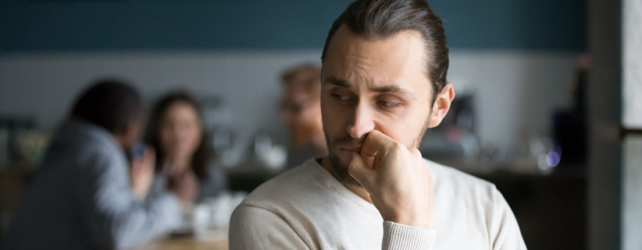 A picture of someone standing away from their family, seemingly stressed.