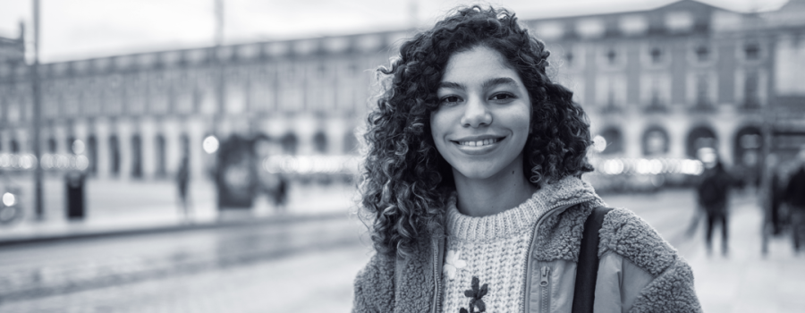 Ciara, a teenage girl, standing outside in front of a university