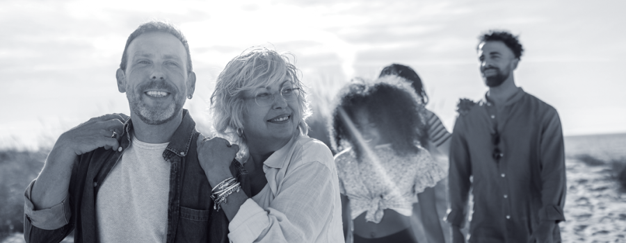 Older couple embracing and walking with older adoptive kids behind them