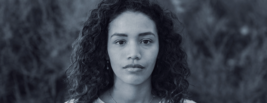 Hispanic woman looking at camera, somber expression on face