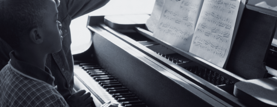 Black teenage boy playing the piano