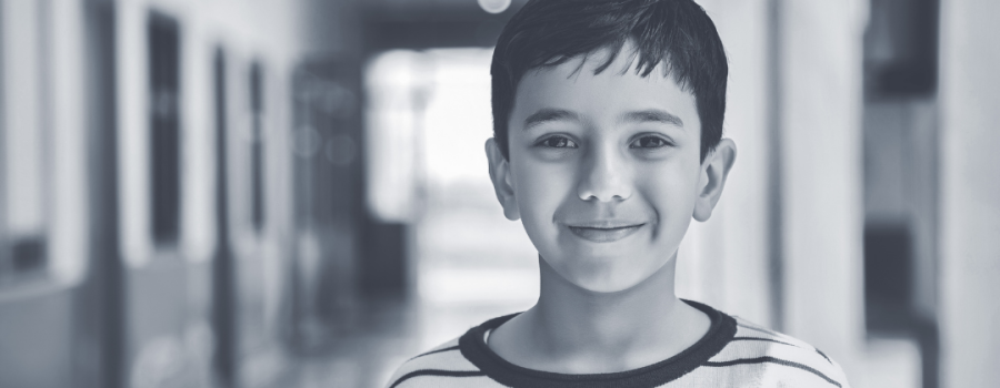 young boy standing in a school hallway