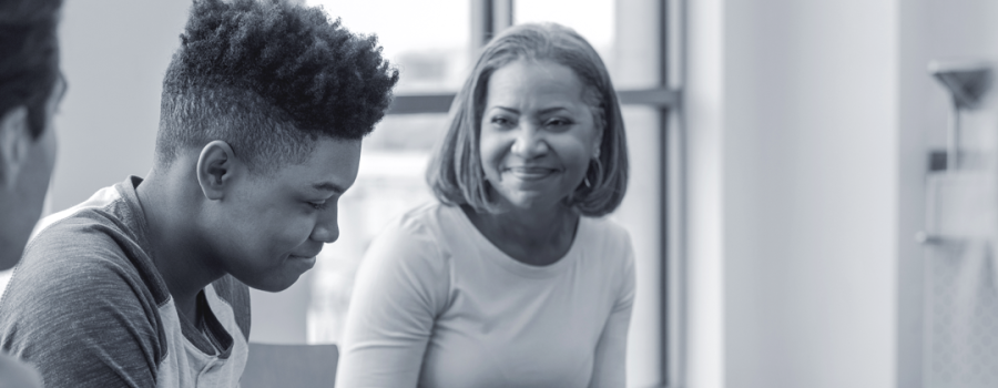 Black teenage boy talking with an adult Black female