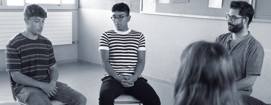 Group of teenagers sitting and conversing in a circle