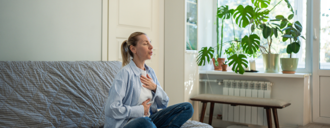 woman self-soothing with deep breaths with hand on chest