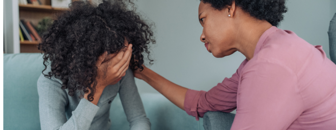 Parent or caretaker consoling a teenage girl in distress