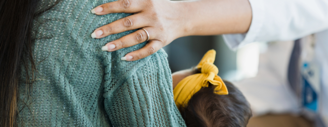 A person's hand on another persons' shoulder.