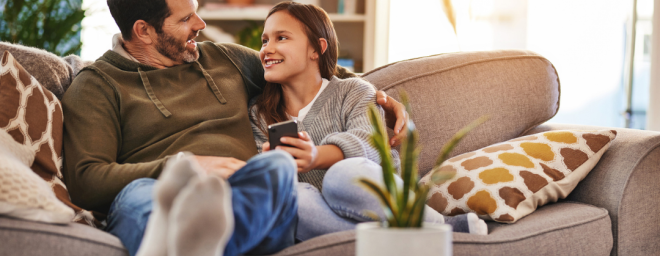 Father sitting on a couch with teenage girl
