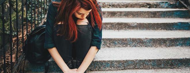 A picture of someone sitting on steps outside.