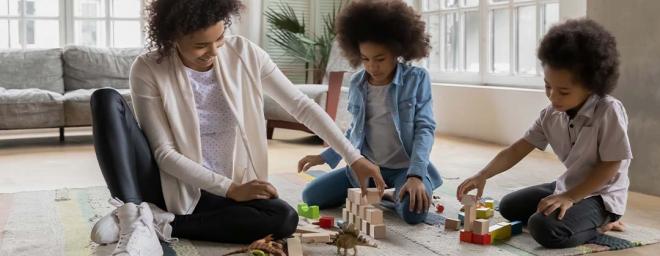 Picture of a parent and two kids playing with toys.