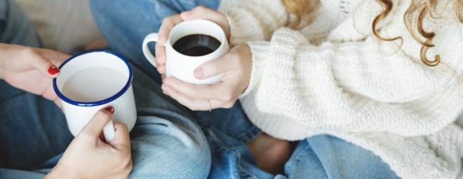 Two people sitting together with coffee.