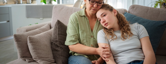 A mother embracing her troubled teenage daughter
