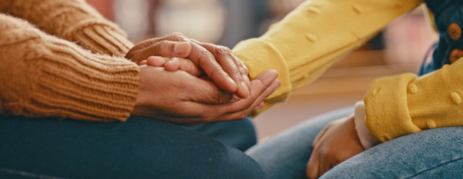 An adult holding a child's hand.