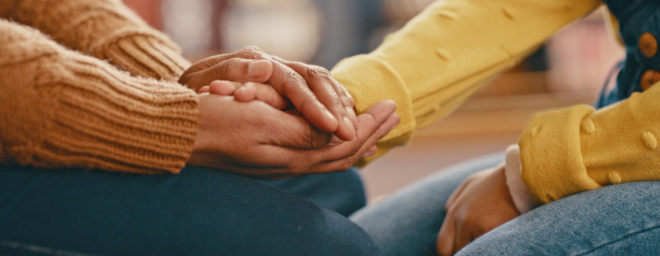 An adult holding a child's hand. 