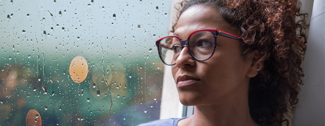 Biracial woman looking out window 