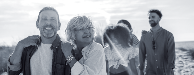 Older couple embracing and walking with older adoptive kids behind them