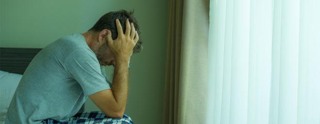 Depressed man holding his head in his hands