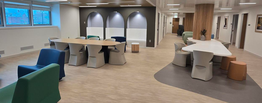 Common space at Hennepin County Youth Stabilization Center featuring tables and chairs, reading nooks, and more.