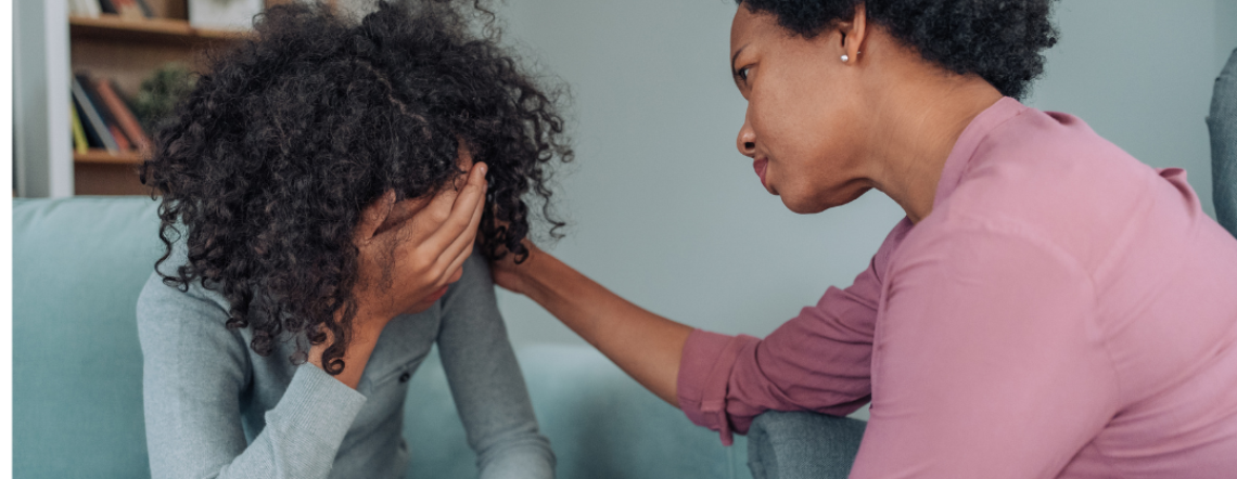 Parent or caretaker consoling a teenage girl in distress