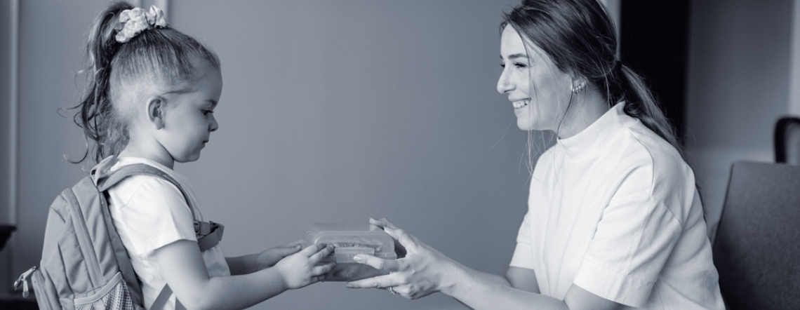 Photo of a woman giving a young child a gift