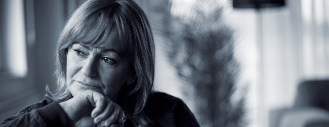 Middle aged woman looking pensively out the window