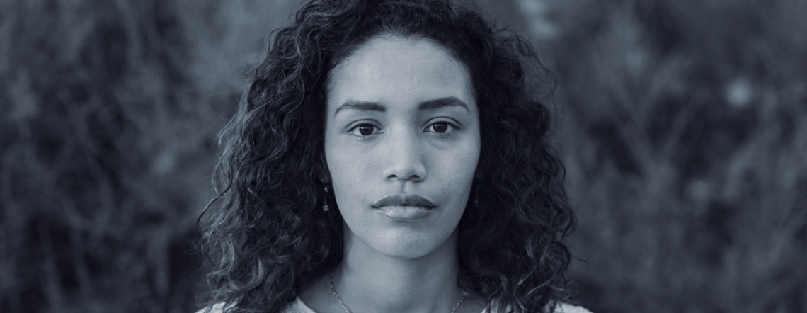 Hispanic woman looking at camera, somber expression on face