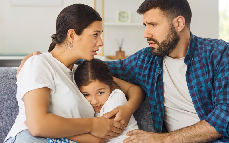 parents comforting a worried child