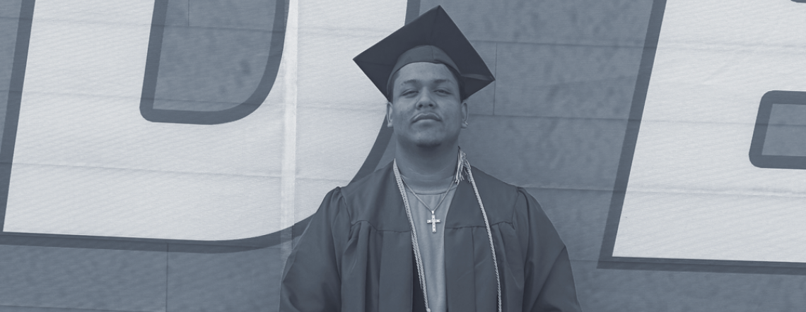 Robin in his cap and gown, holding his high school diploma